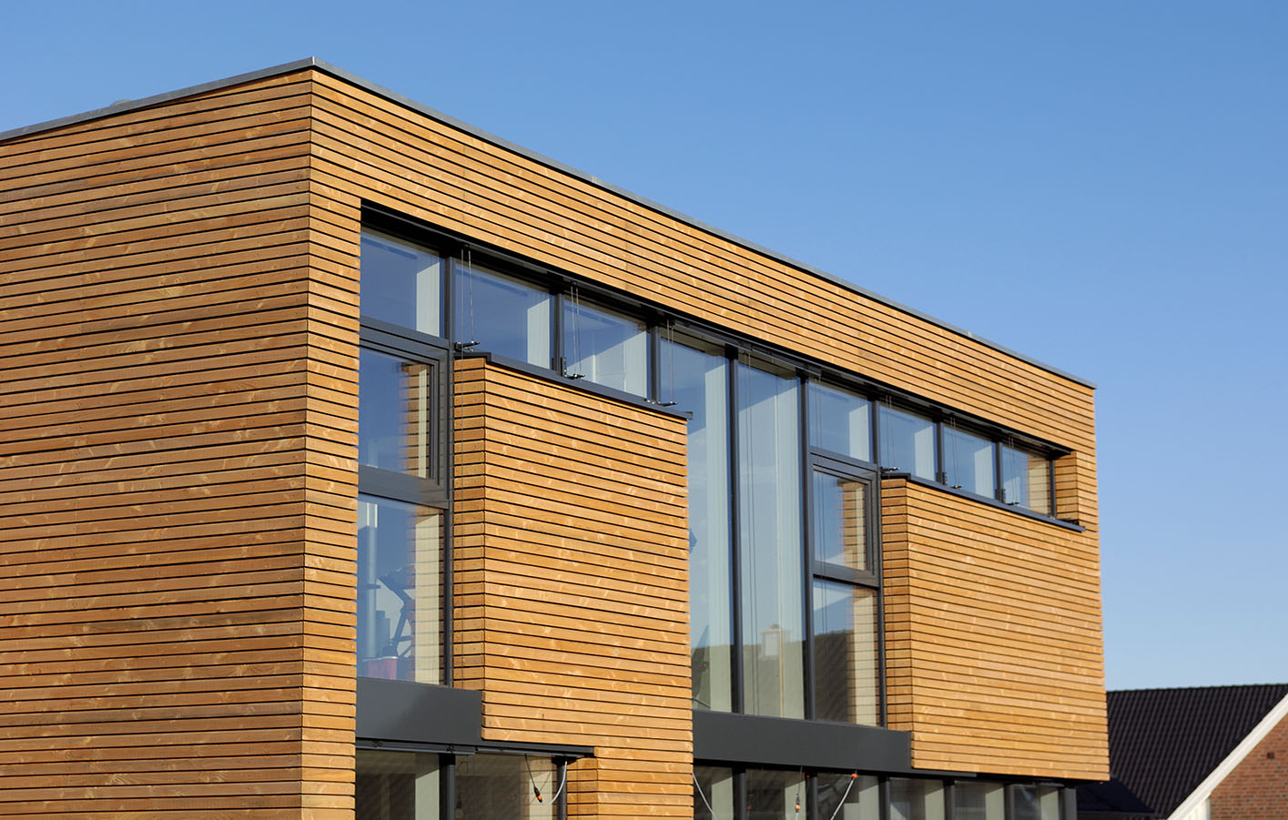 Holzfassade an einem modernen Haus mit großer Fensterfront